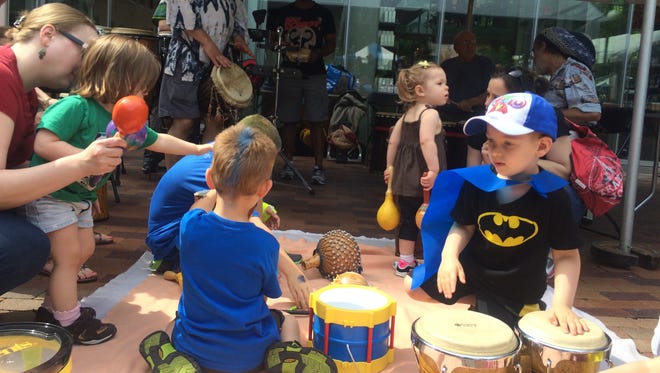 The caped Liam Gilroy, 4, drums along to the Yahoo Drummers with some bongos at the Iowa Arts Festival in this file photo.