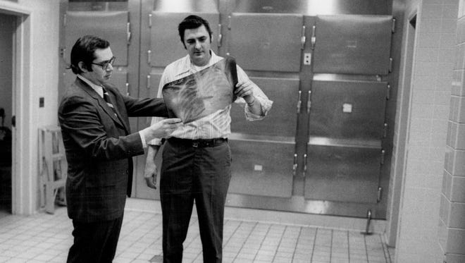 Dr. John Edland, left, and Ed
Riley with an X-ray image in Monroe County Medical Examiner's Office in 1972.