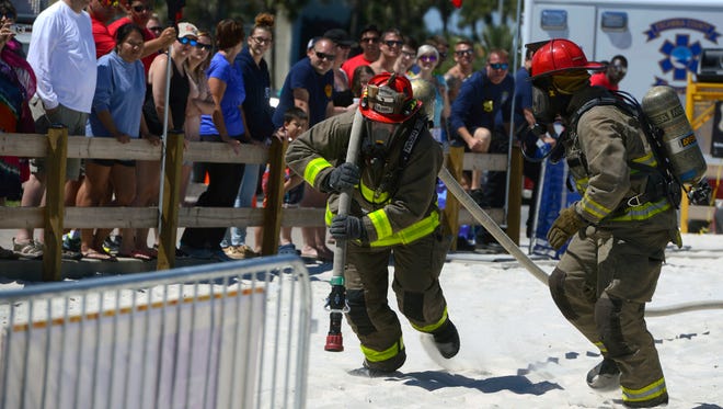 Firefighters compete against the clock Saturday during the Beach Firefighter Challenge at Pensacola Beach.