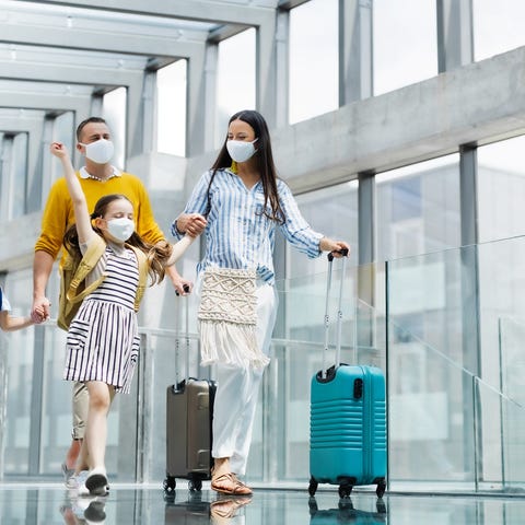 A family wearing masks walking in an airport.