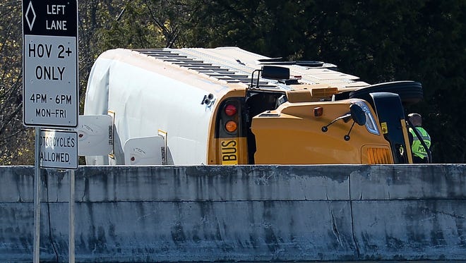 Emergency personnel investigate the scene of a rollover school bus crash on the offramp of the I-65 at Briley Parkway on  Friday, Nov. 18, 2016, in Nashville, Tenn.