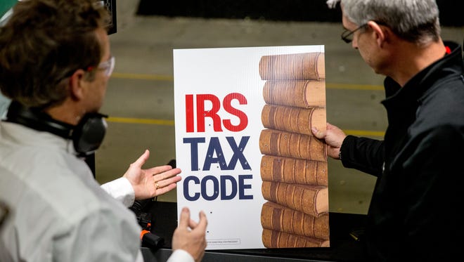 Republican presidential candidate Sen. Rand Paul, R-Ky., left, speaks with General Manager Tom Hudson, right, after firing an AR-15 rifle at an "IRS Tax Code" sign at CrossRoads Shooting Sports in Johnston, Iowa, Sunday, Jan. 17, 2016.