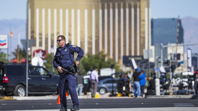 Nevada Highway Patrol trooper Jones stands at a roadblock on Las Vegas Blvd. and Sunset Road with Mandalay Bay in the background Monday morning, October 2, 2017. At least 58 people were shot to death at a country music concert near Mandalay Bay, Sunday evening, Oct. 1, 2017.