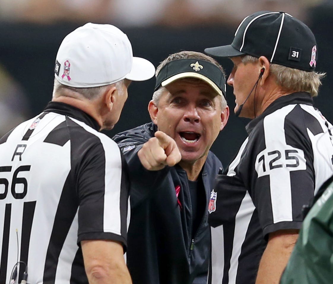 New Orleans Saints head coach Sean Payton talks to referee Walt Anderson (66) and side judge Laird Hayes (125) in the second half of their game against the Carolina Panthers at the Mercedes-Benz Superdome.