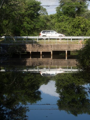 Motorists travel over Jones Creek, Tuesday, May 1, 2018. Escambia County failed to obtain a grant to build a bridge over waterway on Old Corry Field Road. The culvert over Jones Creek on the road was washed out in the 2014 flood and rebuilt, but the county wants to build a bridge over the creek, to guard against future floods closing road.