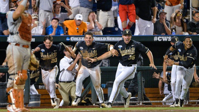Vanderbilt players dash from the dugout as a single by Tyler Campbell in the 10th inning scored Rhett Wiseman for a 4-3 win over Texas in an NCAA baseball College World Series game in Omaha, Neb., Saturday, June 21, 2014. Vanderbilt advances to the championship series. (AP Photo/Ted Kirk)