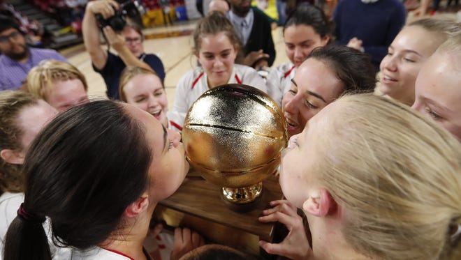 Chaparral players kiss the trophy after beating Mesquite in the 5A Girls State Basketball Championship game at Wells Fargo Arena in Tempe, Ariz. February 27, 2018.