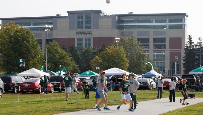 Young kids play in a field while tailgating in the shadow of Spartan Stadium for the Michigan State football game against Eastern Michigan in East Lansing on Saturday, September 20, 2014.