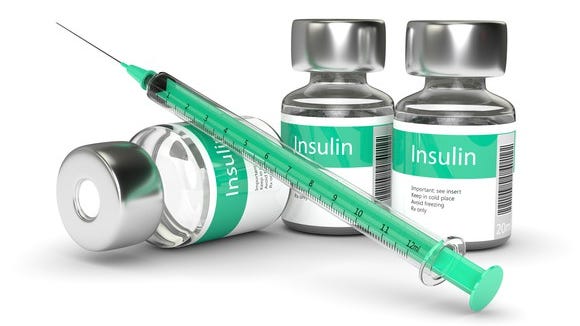 Insulin bottles and a syringe on a table