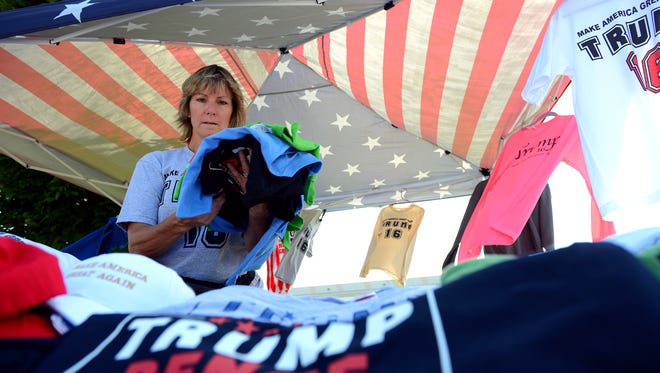 Lori Levi, from Canton, gets her booth ready for the rally outside the Summit Sports and Ice Complex before the Donald Trump, the GOP presidential candidate, campaign rally Friday, August 19, 2016 in Dimondale. Levi said she has been to 40 states in the past year following Trump on the campaign trail.
