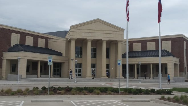 Construction workers and students walk near the entrance of Rock Hill High School on July 29. The campus, which is scheduled to open Aug. 12, is Prosper ISD's second high school.
