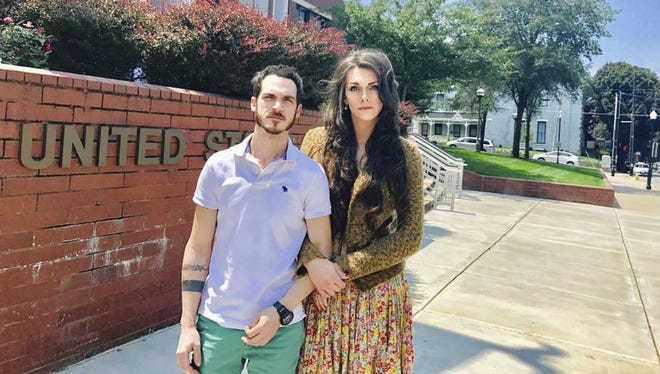 This Aug. 4, 2017, photo provided by Jillian Weiss shows Dane Lane, left, and his transgender wife, Allegra Schawe-Lane, outside the federal courthouse in Covington, Ky. The couple is filing a lawsuit against Amazon, alleging that they endured sustained discrimination and harassment during a year as co-workers at an Amazon warehouse in Kentucky.