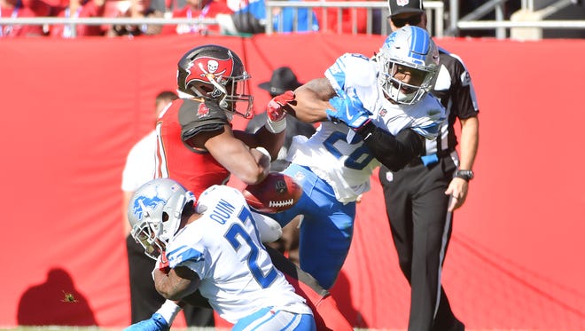 The Lions' Glover Quin and Quandre Diggs cause a fumble that Darius Slay recovered in the first quarter on Sunday against the Buccaneers.