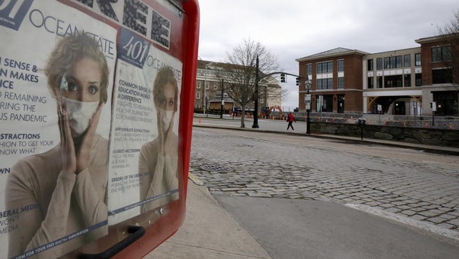 Magazine covers that make reference to the coronavirus sit behind plastic in a magazine dispenser box on a nearly empty street, Wednesday, April 8, 2020, in Newport.