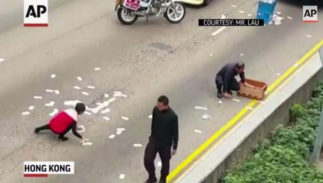 On Christmas Eve, people jumped out of their cars to collect money after a security vehicle spilled $2 million on a Hong Kong road.