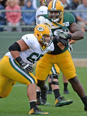 Defensive lineman Letroy Guion (98) battles offensive guard Lane Taylor (65) during Green Bay Packers Training Camp at Ray Nitschke Field August 20, 2015.
