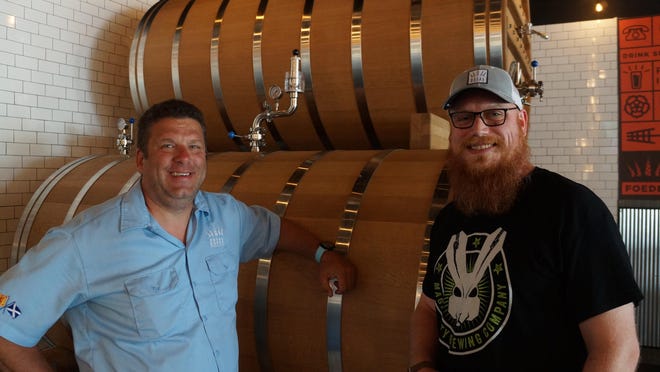 Royal Docks Brewing Co. brewmaster Dave Sutula and cellarman Zane Charnas stand in front of the foeders that will be used to age beer at the new Royal Docks Foeder House + Kitchen in Plain Township. The new brewpub opens Friday.