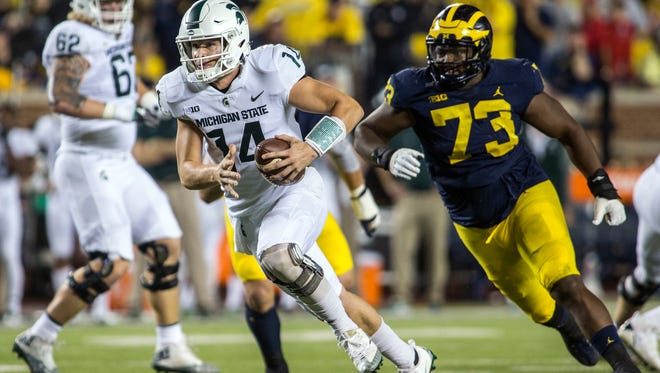 Michigan State quarterback Brian Lewerke (14) rushes ahead of Michigan defensive lineman Maurice Hurst (73) for a touchdown in the first quarter of an NCAA college football game in Ann Arbor, Mich., Saturday, Oct. 7, 2017.