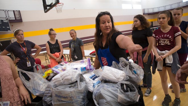 Salvation Army Thrift Store manager Sierra Lobato, center,  directs volunteers from San Juan College High School's student senate, Thursday at the Health and Human Performance Center At San Juan College.