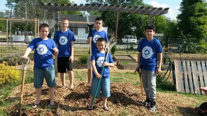 As part of the Family Strengthening Network’s second annual Family Day of Service, Aidan Henderson, Raymier Martinez and Gary, Jake and Evan Boggs, worked together to distribute mulch in the community garden at the Boys & Girls Club of Vineland’s Carl Arthur Center.