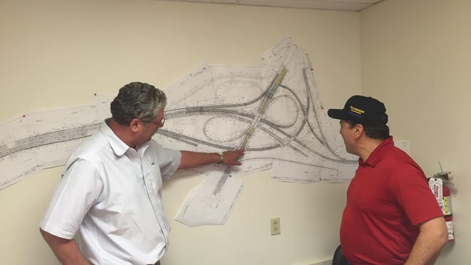 Jim Lating and Javier Torrijos study a map of the U.S. 202, I-95 interchange at a DelDOT office near Wilmington. That project will be complete in July.