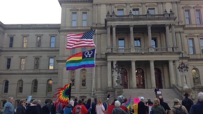 A gay pride flag is carried outside the Capitol