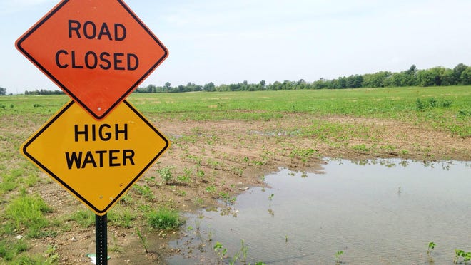 Farm roads are blocked as floodwaters cover land.
