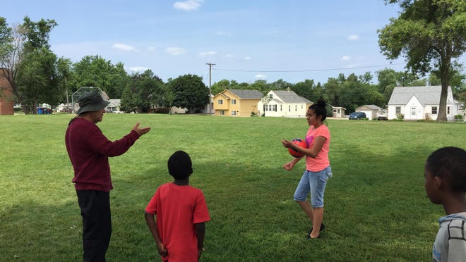 Roberto Duarte, a resident of the Whittier Neighborhood, coaches kids including his daughter, Evelyn (in pink) in an impromptu game of soccer at Meldrum Park.