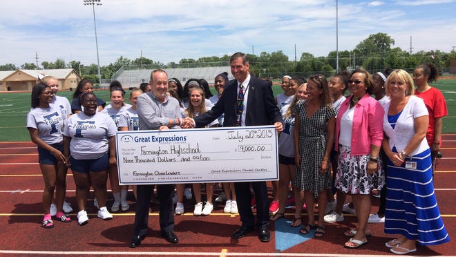 Richard Beckman, CEO of Great Expressions Dental Centers, presented a check for $9,000 to FPS Superintendent George Heitsch and the Farmington High School cheer team.
