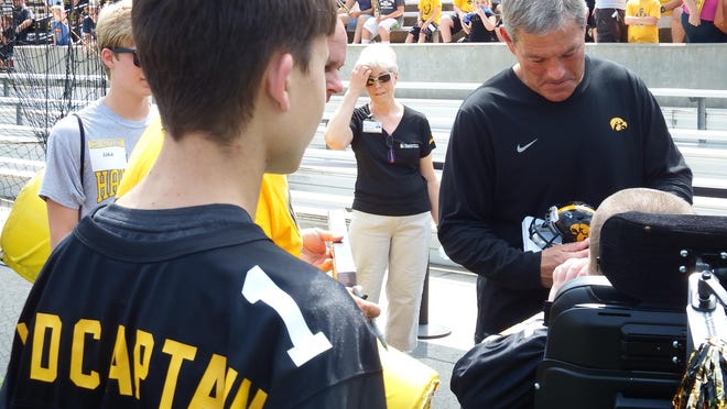 UI Hawkeye head coach Kirk Ferentz autographs items for Kid Captains at Kinnick Stadium on Aug. 15.