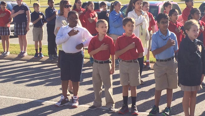 Students sing the national anthem at the University School of Jackson Monday.