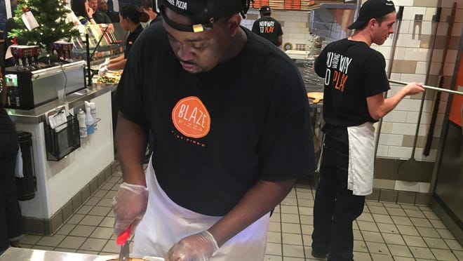 Employees at Blaze Pizza prepare pizza from nine pre-selected options.