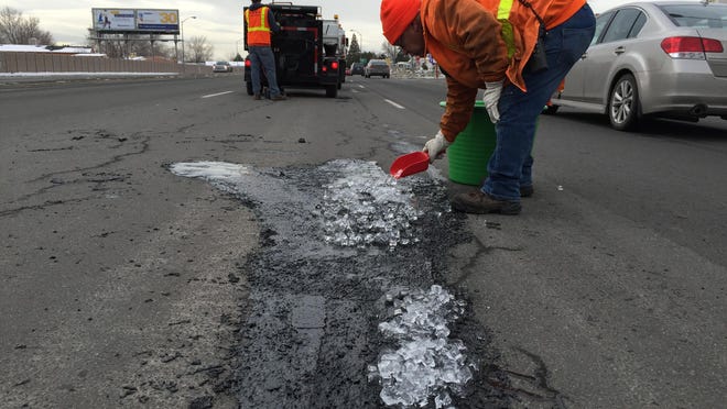 An RGJ file photo of a Reno road crew worker patching a pothole on Oddie Boulevard in 2016.