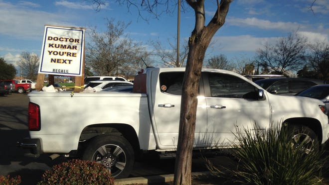 A parked truck at Evolutions Fitness and Wellness carries a sign calling for the recall of Dr. Parmod Kumar from the Tulare Regional Medical Center Board of Directors.
