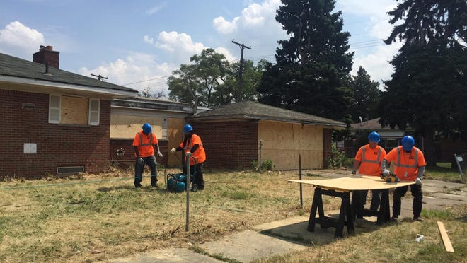 Board-up workers work at a property in Detroit on Thursday as Mayor Mike Duggan details the city’s efforts to combat blight.