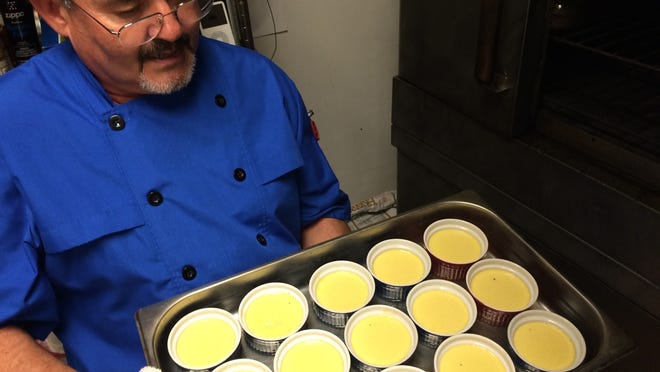 
Chef-owner Christian Vivet pulls ramekins of creme brulee from his oven at Blue Windows Bistro in south Fort Myers.
