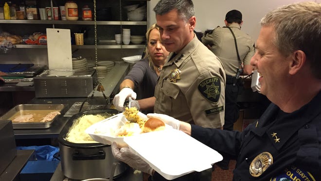 Marion County Sheriff Jason Myers and Stayton Police Chief Rich Sebens pitch into during the 9th Annual Community Thanksgiving Dinner at Stayton's Covered Bridge Cafe.