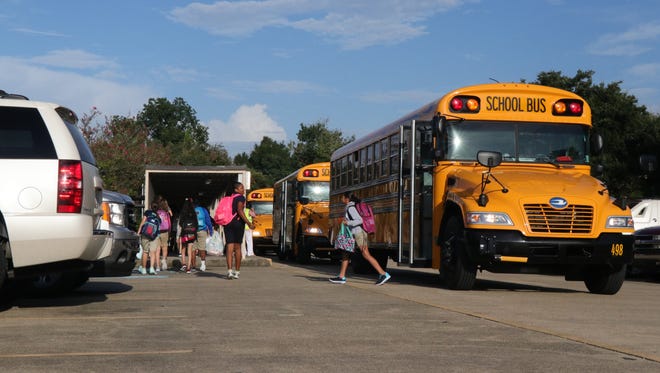 Buses drop off students at L.J. Alleman Middle in August.