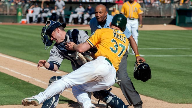 Chris Stewart of the Yankees tags out the A's Brandon Moss on a collision at the plate in the 15th inning of a game on June 13. Oakland eventually won 3-2 in 18 innings.