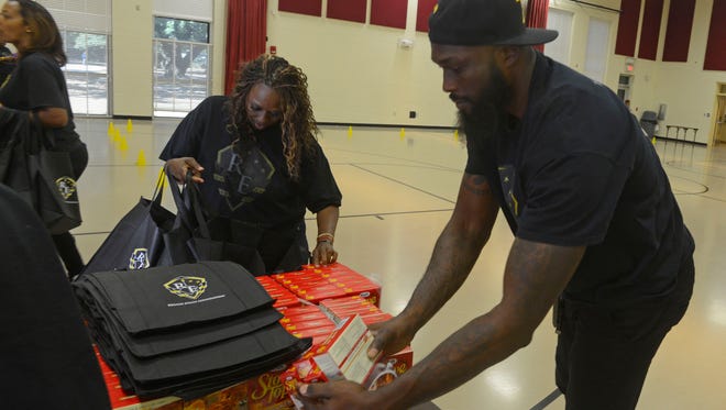 Pro basketball free agent Reggie Evans puts togehter food bags Saturday during the Reggie Evans Foundation Annual Turkey Giveaway at the Woodland Heights Resource Center. Reggie gave away 400 turkeys with stuffing and green beans.
