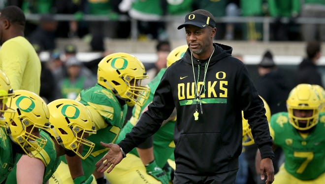Oregon head coach Willie Taggart, center, greets his players during warmups before an NCAA college football game against Arizona Saturday, Nov. 18, 2017.