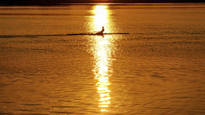 An early morning rower glides through the glare of the rising sun on the Potomac River at the start of a hot day in Washington, Saturday July 20, 2019. Temperatures in the Nation's Capital are expected to reach the upper 90s. (AP Photo/J.David Ake)