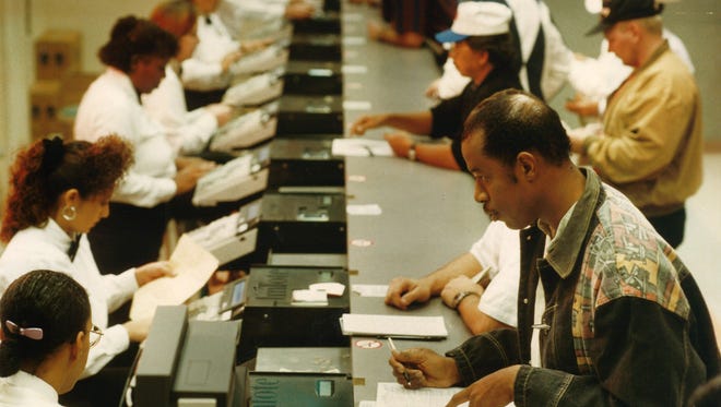 Greg Ivey of San Antonio (bottom right) places a bet prior to a race Jan. 13, 1995 at the Corpus Christi Greyhound Racetrack.