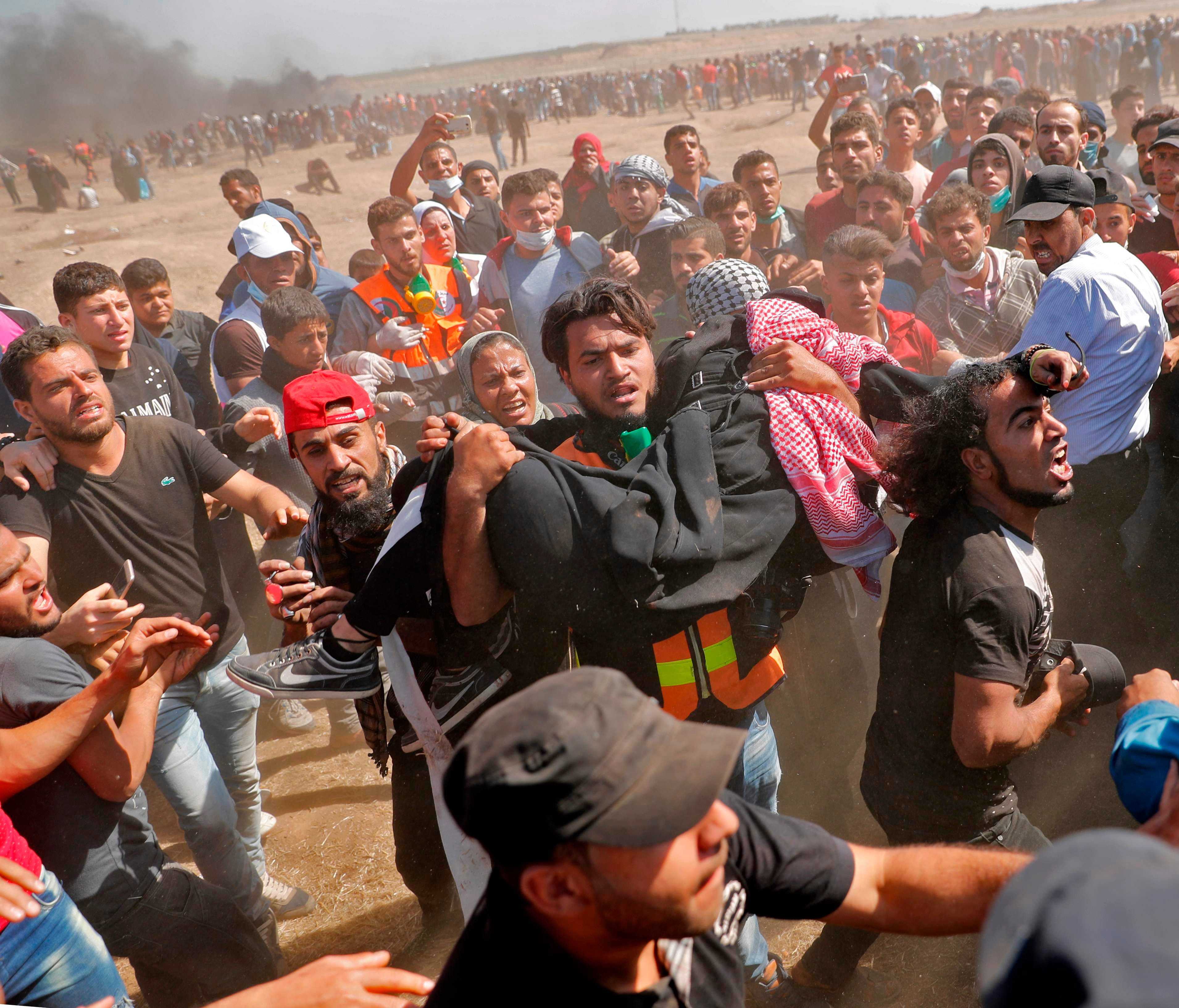 Palestinians carry a demonstrator injured during clashes with Israeli forces near the border between the Gaza strip and Israel east of Gaza City.