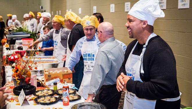 Chefs prepare their tables for hundreds of participants during 100 Men Who Cook at the Horizon Convention Center Saturday night. The event, which pits community leaders against one another in a "top chef" competition, raised funds for the Community Champions Fund. 