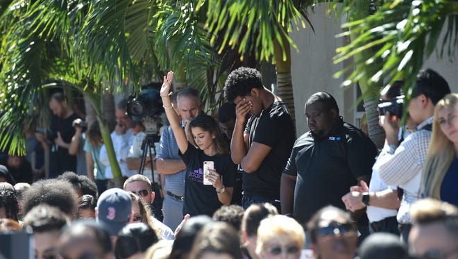 Students bow their heads in prayer along with the crowd during the community prayer vigil for Marjory Stoneman Douglas High School shooting victims on Thursday, Feb. 15 at Parkridge Church in Coral Springs.