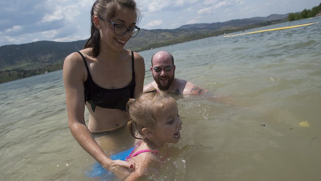 America Wright and her daughter Olivia, 3, take a dip in Horsetooth Reservoir to escape the heat as temperatures climb into the 90s across Northern Colorado.