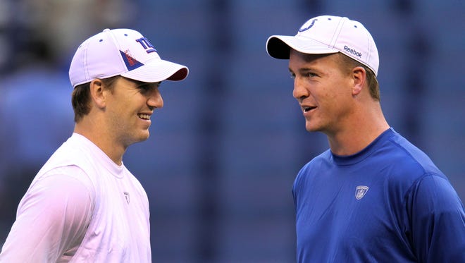 Indianapolis Colts quarterback Peyton Manning (right) talks with his brother, Eli Manning, quarterback for the New York Giants, before the game at Lucas Oil Stadium in Indianapolis on Sept. 19, 2010.
