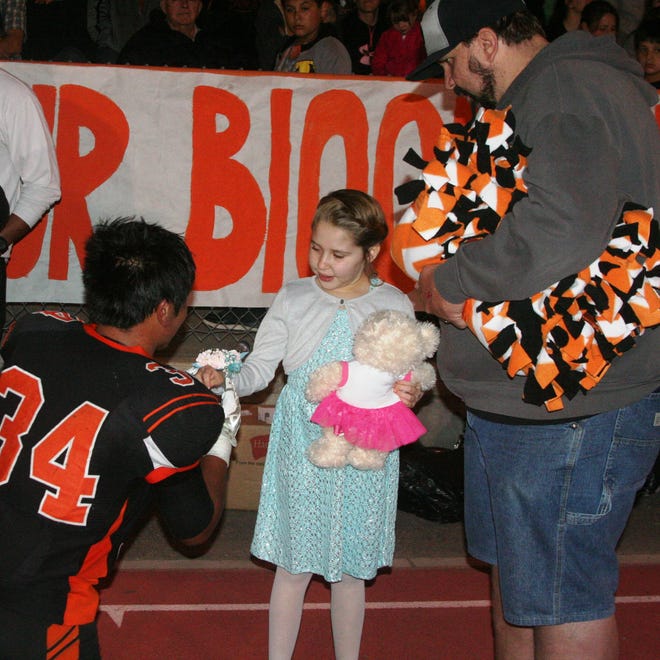Brian Reyes places a corsage on Haylie Chmela’s wrist while her father, Jeff Chmela, looks on before she was introduced as Fernley High School’s Homecoming Queen last Friday.
