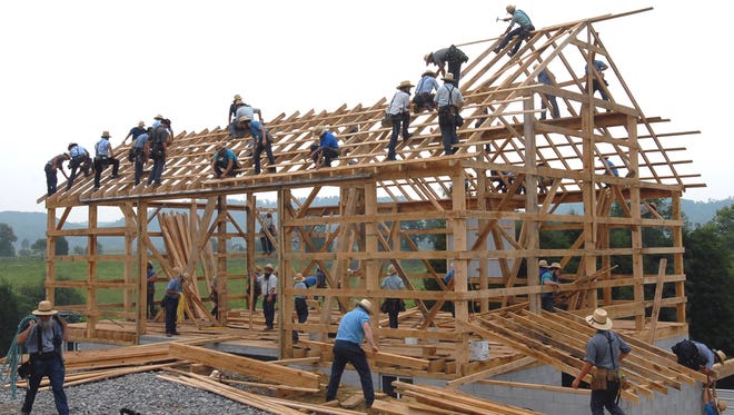 Amish workers raise a new barn near Tollesboro, Ky. Many Amish work in construction and manufacturing, with farming becoming a smaller part of their employment.